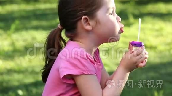 快乐的孩子在公园里吹肥皂泡
