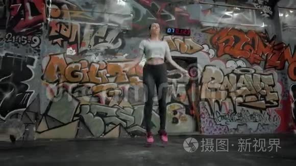 美丽的运动女性在交叉健身馆用跳绳锻炼，女孩运动员跳跃