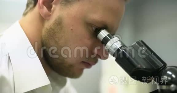 科学家正在研究显微镜和平板上的书写数据。