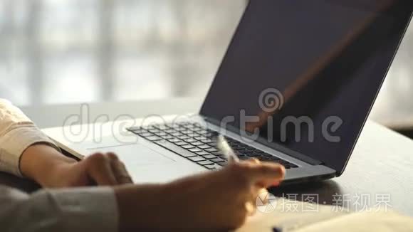 一只正忙着在笔记本电脑上打字的女性手