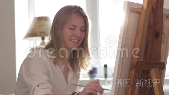女画家坐在窗边画水彩画视频
