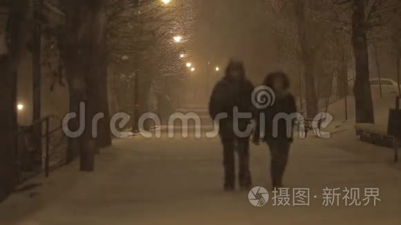 晚上在暴风雪中散步的夫妇