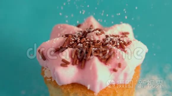 把冰糖筛在粉红色的糖霜蛋糕上视频