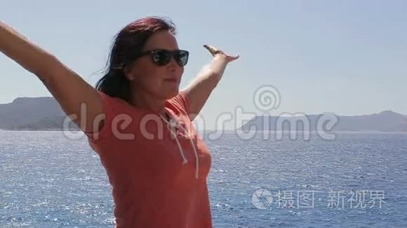 美丽的女人享受阳光和大海视频