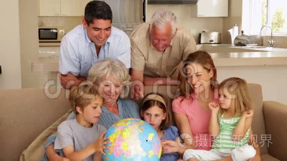 一家人一起在沙发上看地球仪视频