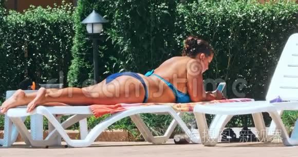 女人在泳池边的椅子上晒日光浴视频