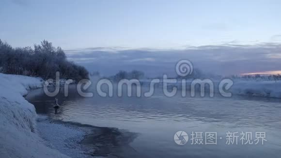 晨曦在江上浓霜.. 在严寒中从水中蒸发。