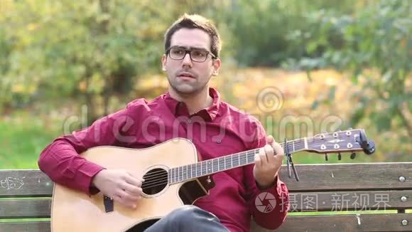 男子在公园弹声吉他和唱歌视频