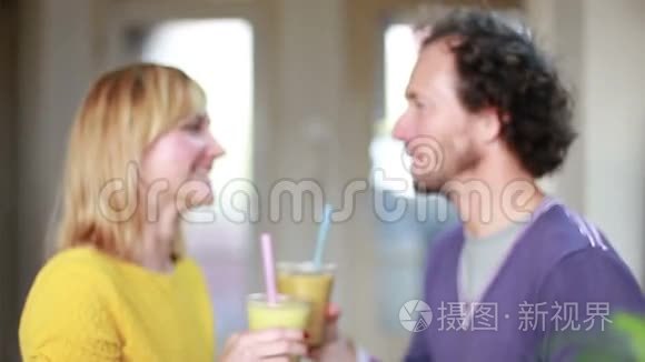 快乐的一对夫妇品尝和喝水果冰沙