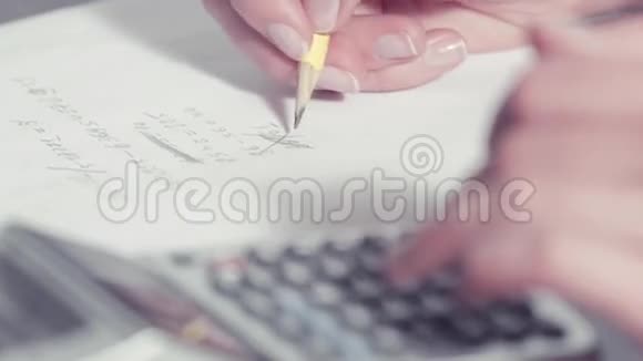 女人用铅笔写字，用计算器打字视频的预览图