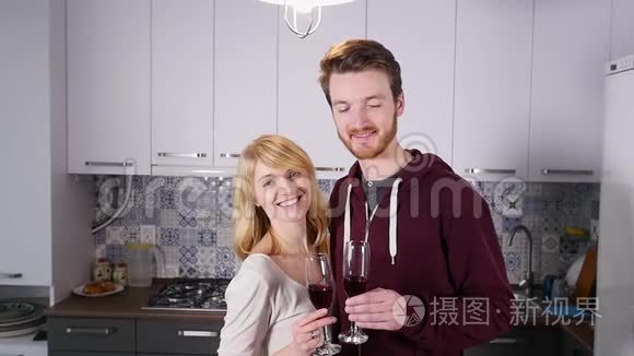 年轻夫妇在家里的厨房里喝红酒视频