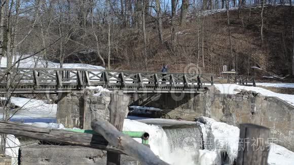 儿童背包旅行复古木桥冻河瀑布视频