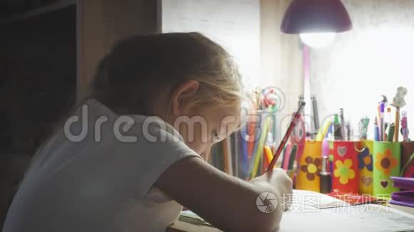 小女孩在灯光下在桌子上做作业。 小公主的创作爱好.. 生活方式