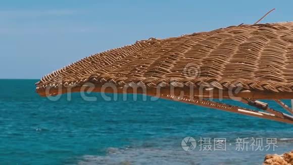 在红海的珊瑚礁背景下，带着雨伞的空海滩