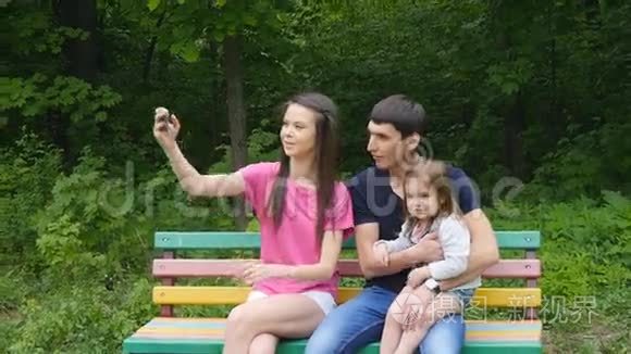 公园智能手机自拍的幸福家庭