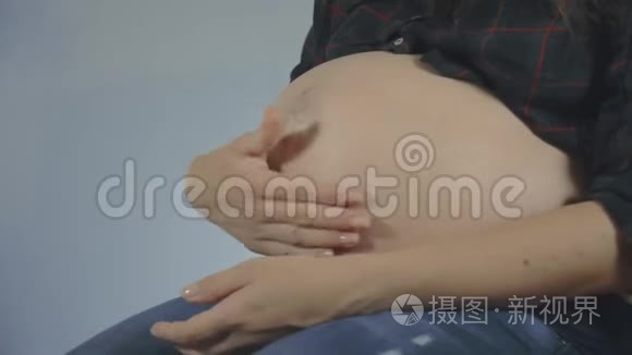 孕妇抚摸她的腹部。