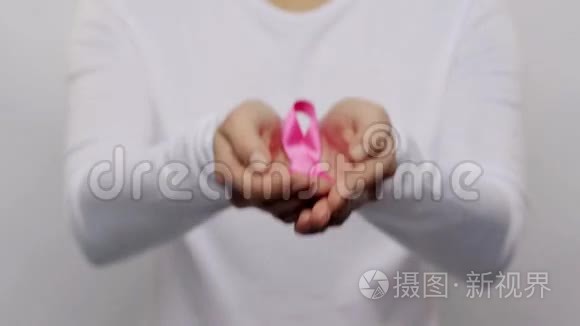 女人拿着粉红色的癌症意识丝带视频