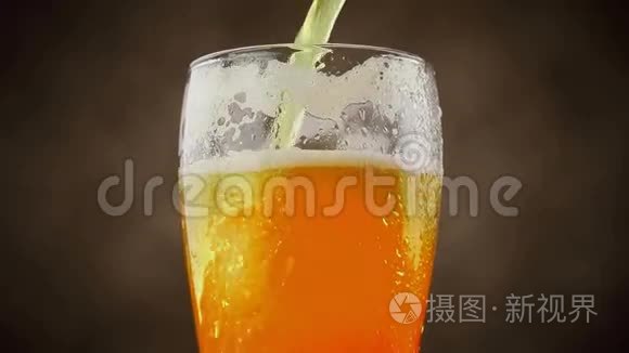 在棕色背景下将泡沫啤酒倒入玻璃杯中