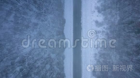 暴风雪中道路和冬季森林的鸟瞰图