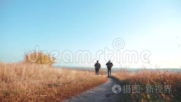 两个背着背包徒步旅行的人正沿着小路爬山。 慢速视频