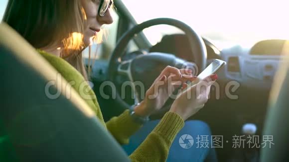 戴眼镜的女人在车里用智能手机