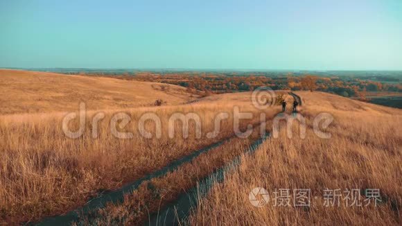 两个背着背包徒步旅行的人正沿着小路爬山。 慢速视频