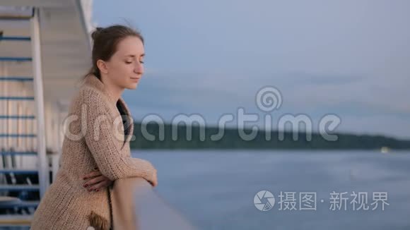 日落后游船甲板上欣赏风景的女人