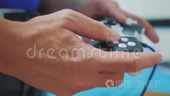 在电视上玩gamepad的人手上有视频控制台。 手握新的操纵杆在电视上播放视频控制台。 玩家玩游戏