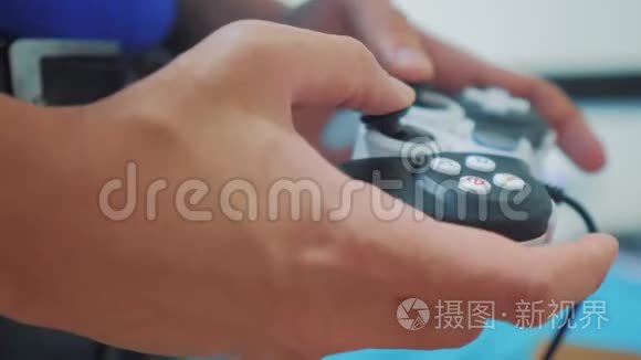 在电视上玩gamepad的人手上有视频控制台。 手握新的操纵杆在电视上播放视频控制台。 玩家玩游戏