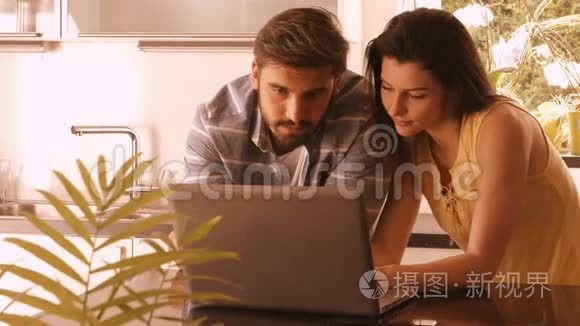 一对夫妇在厨房用笔记本电脑视频