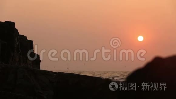 海波背景下日落时的岩石