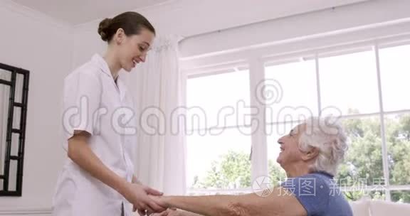 微笑护士帮助老年妇女做运动