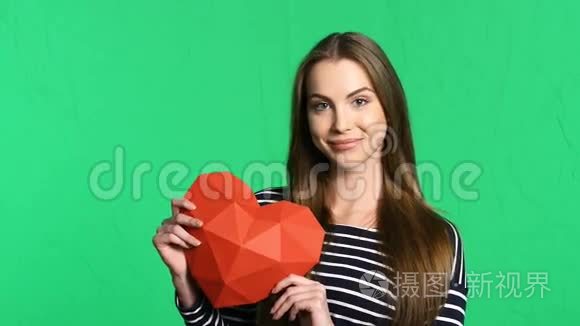 微笑的女人拿着红色多角纸心形视频