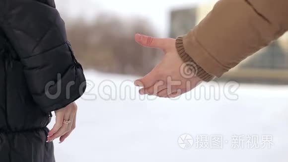 一对夫妇牵着手的特写。