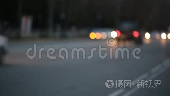 城市在夜间背景与汽车。 重点之外