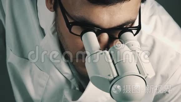 年轻的科学家透过显微镜看视频