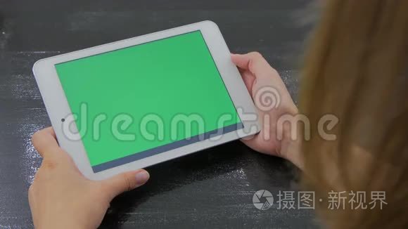 女人看着绿色屏幕的平板电脑