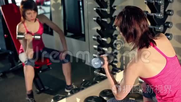 女人在健身房用杠铃做运动。