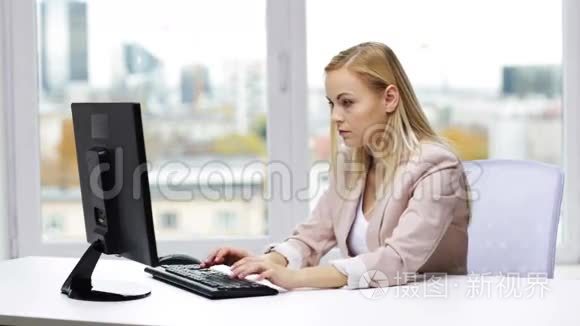 年轻的女商人在办公室里用电脑打字