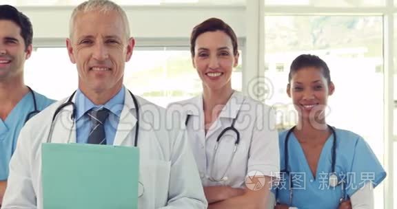 一队微笑的医生看着摄像机视频