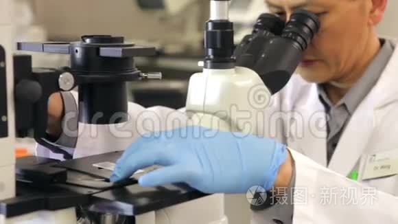 实验室使用显微镜的男性科学家视频