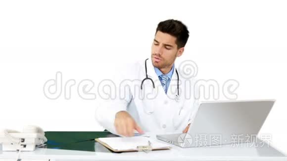 年轻的医生在他的办公桌前工作视频