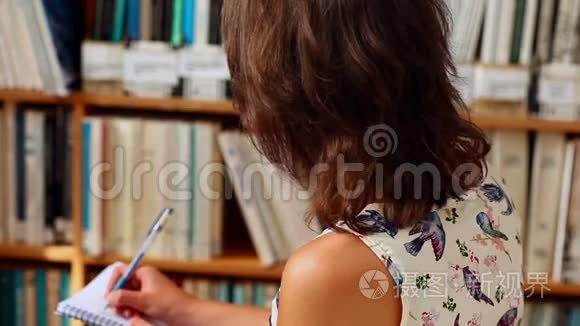 年轻女学生在图书馆写作