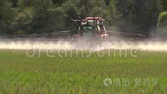农民用拖拉机喷洒夏季绿色小麦作物农田