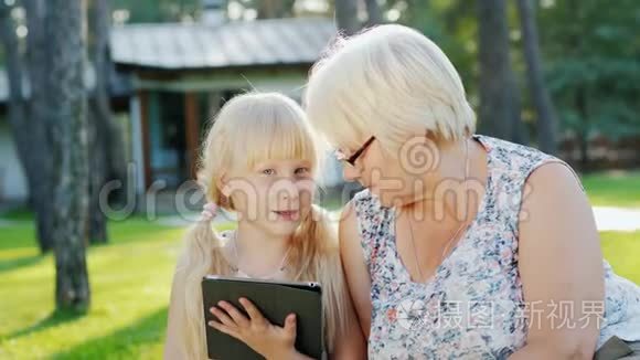 外婆和孙女正在家后院休息，他们一起看着碑，交流..