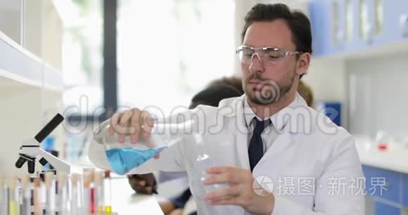 在化学实验室工作时，男性科学家在面粉中倒入液体，戴上白色外套和防护眼镜