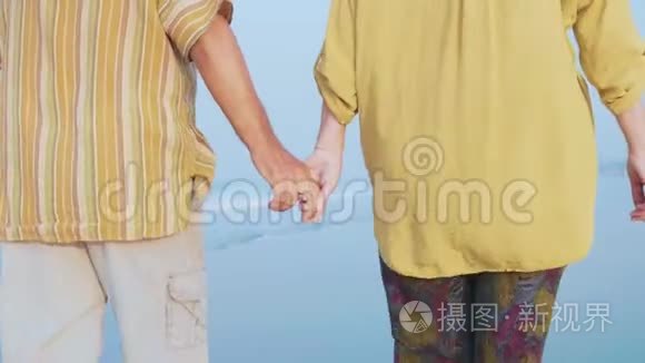 一对老夫妇在海滩上散步聊天，打了一枪