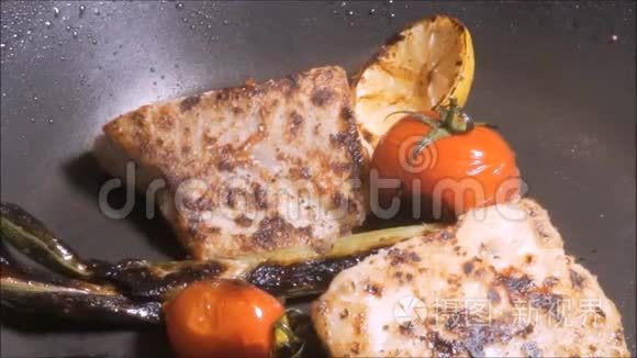 用蔬菜在黑锅上煎鱼。