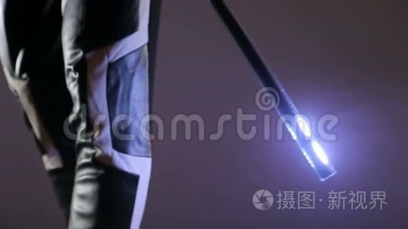 男人手里拿着一根LED棒。 发光二极管手指中的光从底部移动到顶部。 领秀第一部分
