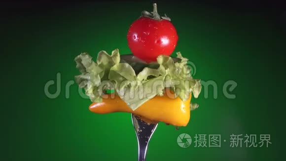 用黄椒片叉黄瓜、萝卜和生菜旋转绿色背景